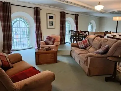 a living room with couches and chairs and a table at Capel Pennal in Pennal