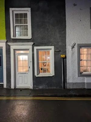 a building with a white door and two windows at Neifion in Aberdyfi