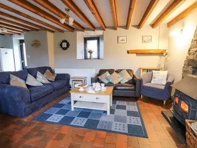 a living room with couches and a fireplace at Old Farmhouse Cottage in New Quay