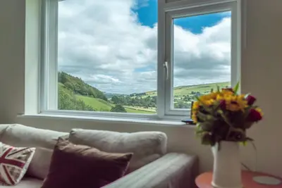 a living room with a couch and a window at Hendre-Llangwm in Llangwm