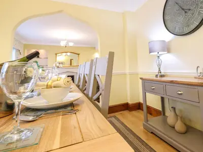 a dining room with a table with a bottle of wine at Llwyn Derw in Talybont