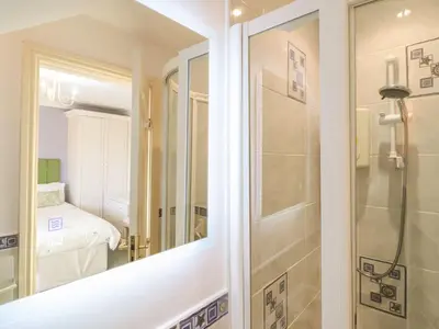 a bathroom with a shower and a mirror at Llwyn Derw in Talybont