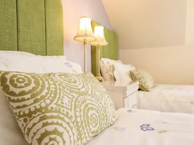 a bedroom with two beds and a lamp and a bed sidx sidx sidx at Llwyn Derw in Talybont