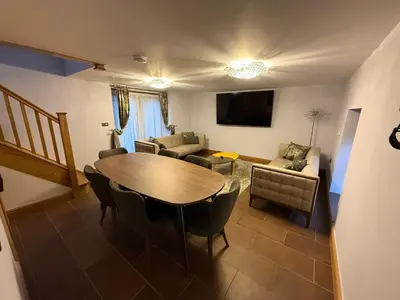 a living room with a wooden table and chairs at Nantsidyll Farm Spa & Holiday Lodges in Mydroilin