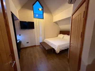 a small bedroom with a bed and a window at Nantsidyll Farm Spa & Holiday Lodges in Mydroilin