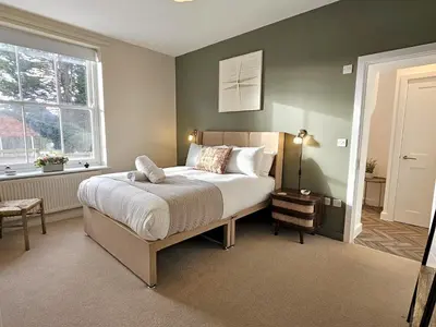 a bedroom with a large bed and a window at Elegant interior-designed ground floor apartment - Pass the Keys in Shrewsbury