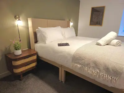 a bedroom with a bed with a bag on it at Stylish and spacious lower ground floor apartment -Pass the Keys in Shrewsbury