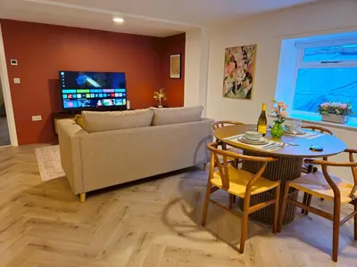 a living room with a couch and a table at Stylish and spacious lower ground floor apartment -Pass the Keys in Shrewsbury
