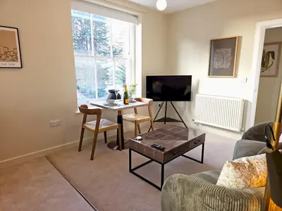 a living room with a table and a tv at Contemporary first-floor apartment close to town - Pass the Keys in Shrewsbury