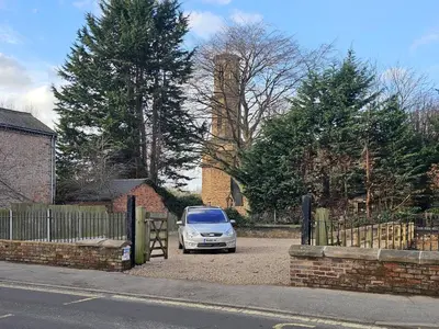 a white car parked in a parking lot with a clock tower at Contemporary first-floor apartment close to town - Pass the Keys in Shrewsbury