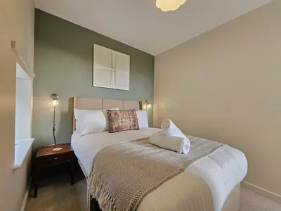 a bedroom with a bed and a table with a lamp at Contemporary first-floor apartment close to town - Pass the Keys in Shrewsbury