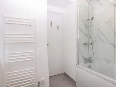 a white bathroom with a shower and a tub at Yr Hen Felin in Dyffryn
