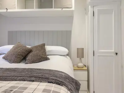 a bedroom with a white bed with gray pillows at Lodge at Nadur in Machynlleth