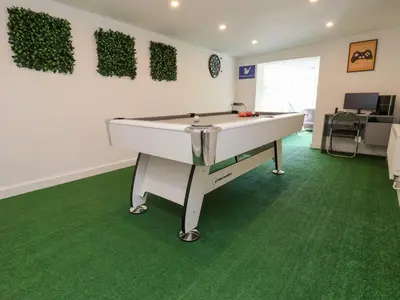 a room with a pool table on a green carpet at Castellolwg in Llangollen