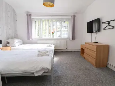 a bedroom with a bed and a tv and a window at Castellolwg in Llangollen