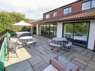 a patio with two tables and chairs and windows at Castellolwg in Llangollen