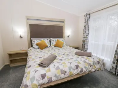 a bedroom with a large bed with pillows on it at Beechwood Lodge in Borth