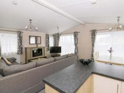 a living room with a couch and a table at Beechwood Lodge in Borth