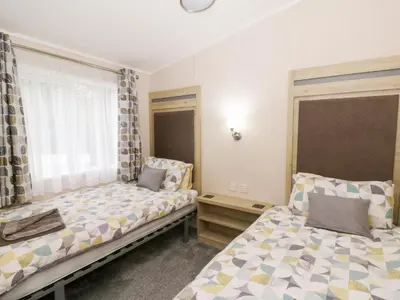a bedroom with two beds and a window at Beechwood Lodge in Borth