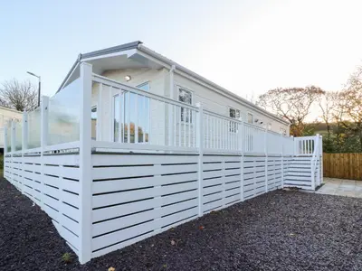 a white house with a window on top at Beechwood Lodge in Borth