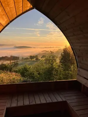 an arched window with a view of a foggy valley at The Granary - Wild Swimming, Sauna, Peace & Quiet, Nr Bala in Corwen