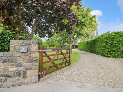 a wooden gate on a stone wall next to a path at 1 Clarkes Lane in Oswestry