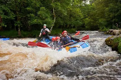 a group of people in a raft in a river at Pengwern in Cerrigydrudion