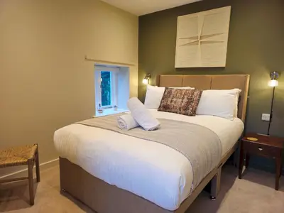 a bedroom with a large white bed with a window at Stylish and newly renovated penthouse apartment - Pass the Keys in Shrewsbury