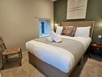 a bedroom with a large bed and a chair at Stylish and newly renovated penthouse apartment - Pass the Keys in Shrewsbury