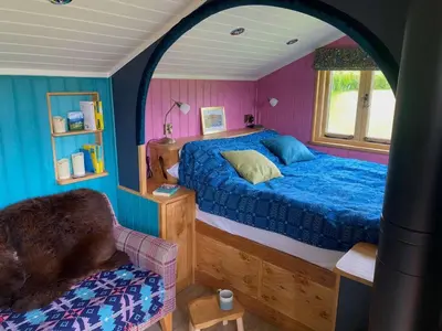 a bedroom with a blue bed and a window at 1 Bed in Llanfihangel-y-Creuddyn oc-c34624 in Llanfihangel-y-creuddyn