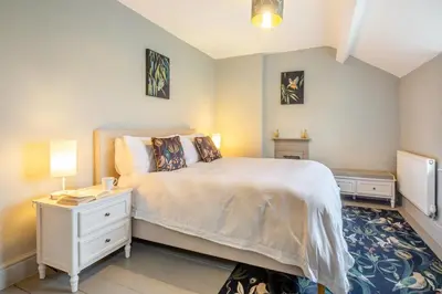 a bedroom with a large white bed and a night stand at 3 Bed in Islawrdref oc-t34600 in Penmaenpool