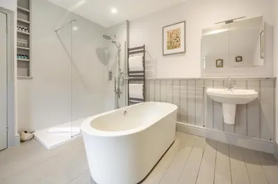 a white bathroom with a tub and a sink at 3 Bed in Islawrdref oc-t34600 in Penmaenpool