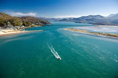 a boat in the water next to a beach at 3 Bed in Islawrdref oc-t34600 in Penmaenpool