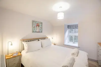 a bedroom with a white bed and a window at 4 Bed in Ganllwyd oc-g34601 in Mallwyd