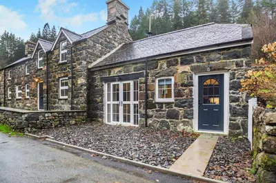 an old stone house with a blue door at 4 Bed in Ganllwyd oc-g34601 in Mallwyd