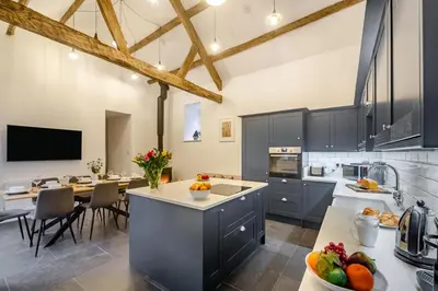 a kitchen with blue cabinets and a dining room at 4 Bed in Ganllwyd oc-g34601 in Mallwyd