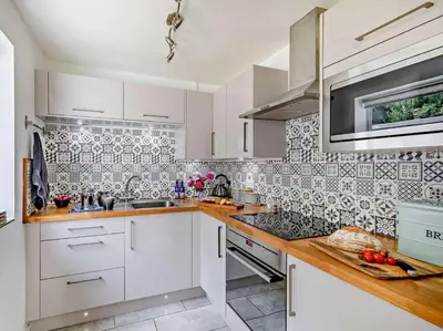 a kitchen with white cabinets and a tile wall at 1 Bed in Leominster oc-78638 in Stoke Prior