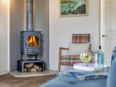 a living room with a wood stove and a chair at 1 Bed in Leominster oc-78638 in Stoke Prior