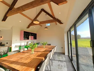 a large dining room with a long wooden table at 7 Bed in Welshpool oc-96412 in Berriew