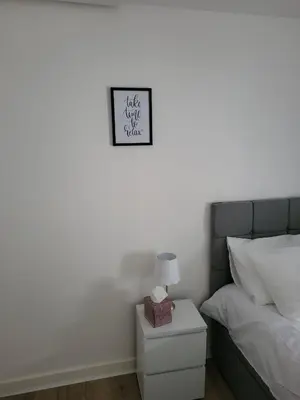 a bedroom with a bed and a clock on the wall at FLAT 2 Seven Cambrian Square First Floor Flat in Newtown