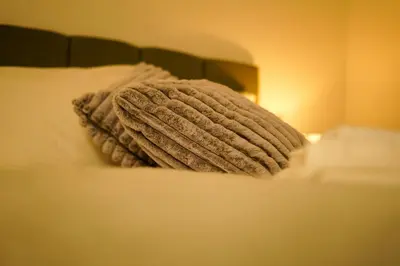 a blanket on a bed next to a lamp at FLAT 2 Seven Cambrian Square First Floor Flat in Newtown