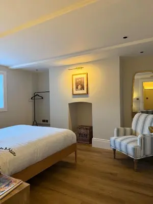 a bedroom with a bed and a chair and a mirror at Spacious Luxury Apartment in the Heart of Shrewsbury Sleeps 6 in Shrewsbury