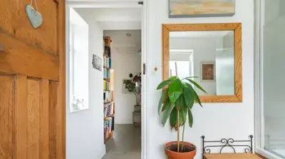 a hallway with a mirror and a potted plant at Spacious 4 bed home to sleep 9, parking for 4 cars in Shrewsbury