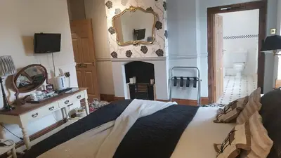 a bedroom with a bed and a mirror and a fireplace at Mortimers Cross Guest House in Mortimer's Cross