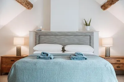 a bedroom with a bed with blue towels on it at Little Whitley - Luxury Country Cottage in Shrewsbury