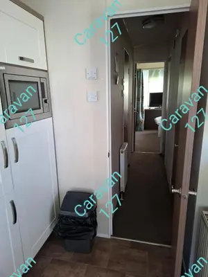 a hallway leading to a room with a door and a hallway at Caravan 127 in Barmouth
