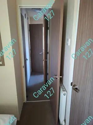 a hallway with a door with a sign that sayschange at Caravan 127 in Barmouth