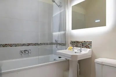 a white bathroom with a sink and a bath tub at Blackhill barn - in the heart of the Cotswolds in Craswall
