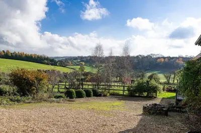 a garden with a fence and a bench and a field at Blackhill barn - in the heart of the Cotswolds in Craswall