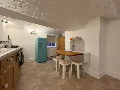 a kitchen with a table and a blue refrigerator at Charming 2 Bed House in Central Shrewsbury in Shrewsbury